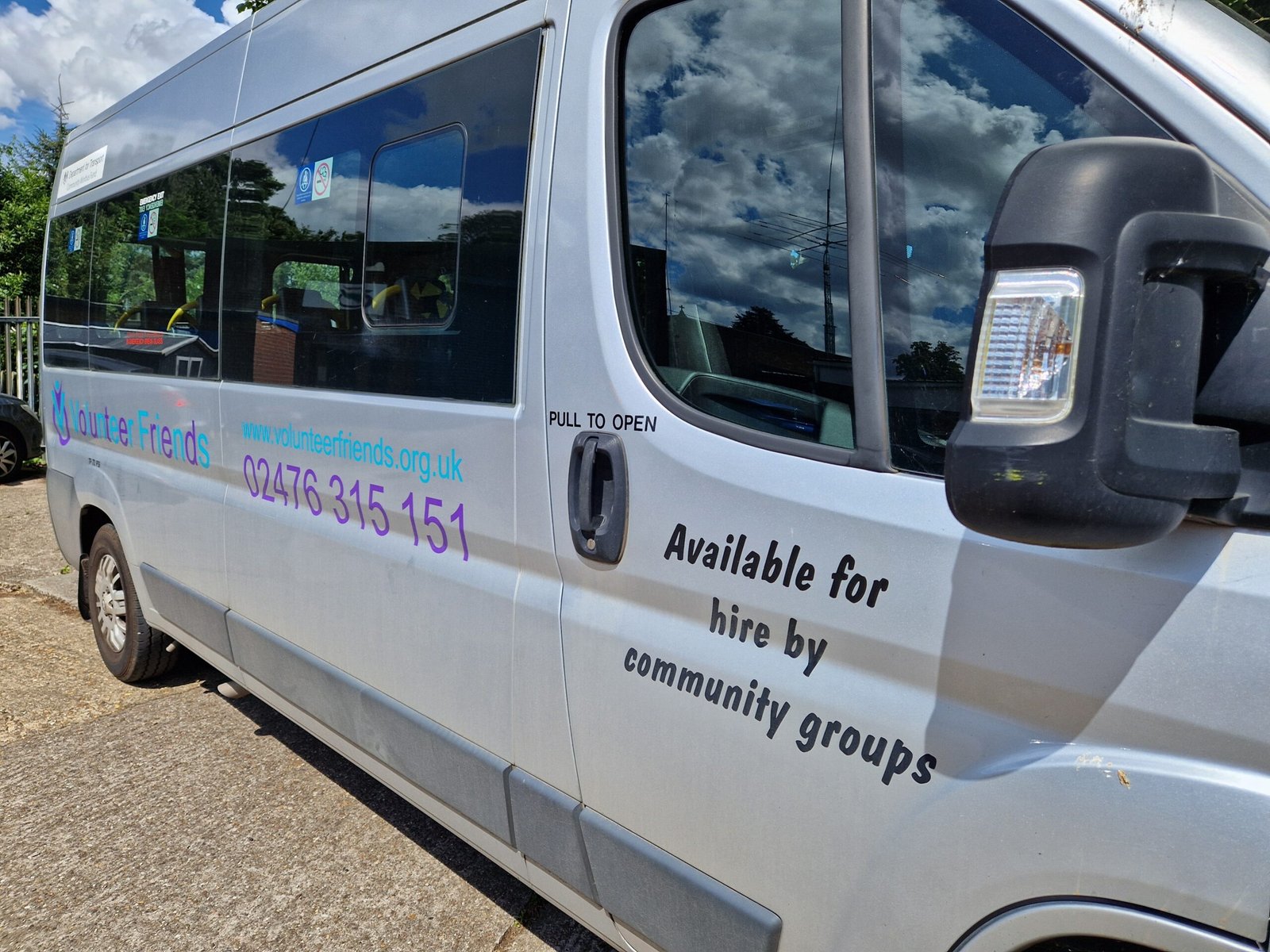 Image of 1 of Volunteer Friends fully accessible minibuses. Has Volunteer Friends logo, contact number and website details on.